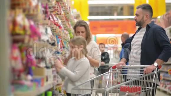 美丽的夫妇和他们的女儿在超市购物时很开心视频的预览图