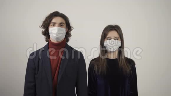 男人和女人微笑着摘下医疗面具的正面景色视频的预览图