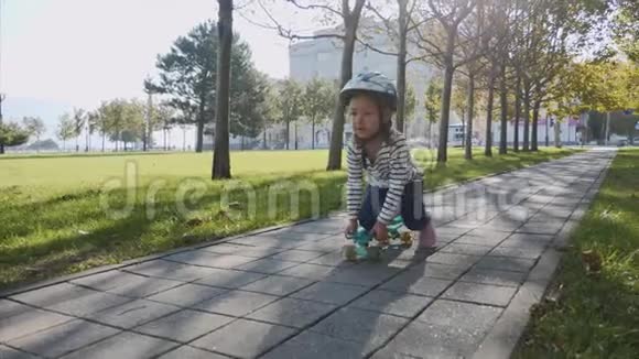 一个女孩坐在滑板上用一条腿推着自己稳定视频的预览图