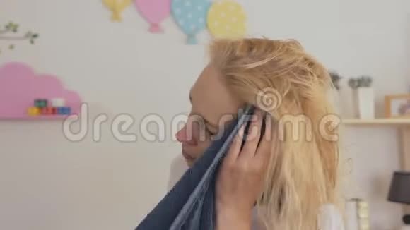 一位中年妇女洗完头后用毛巾擦拭头发视频的预览图