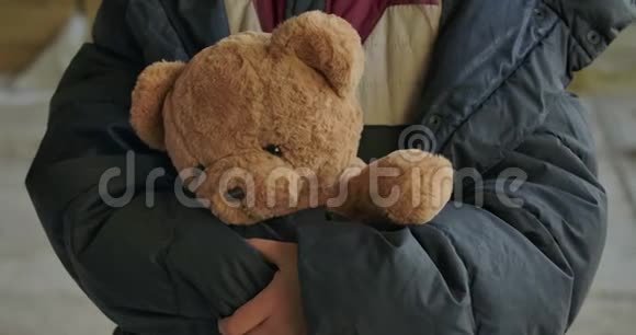 无家可归女孩的特写她手里拿着泰迪熊疲惫的难民站在她可爱的玩具视频的预览图