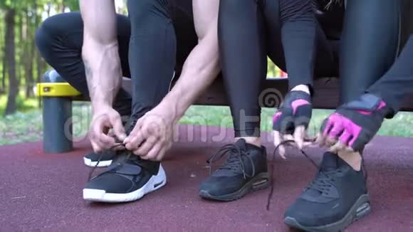在户外训练前男人和女人把鞋带系在运动鞋上视频的预览图