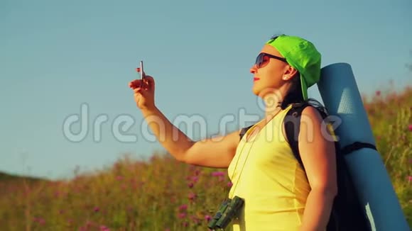 女徒步旅行者在山上背着背包双筒望远镜自拍视频的预览图