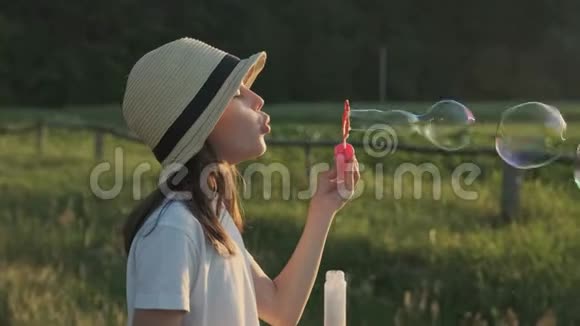 戴帽子吹肥皂泡的漂亮女孩视频的预览图