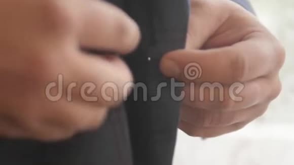穿西装的时髦男人扣紧纽扣挺直夹克准备出门为婚礼做准备视频的预览图