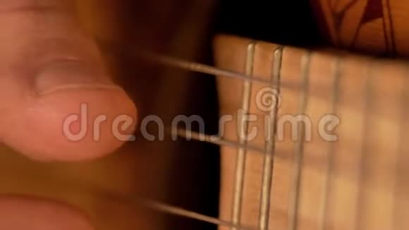 男性手指演奏古典吉他的琴弦特写视频的预览图
