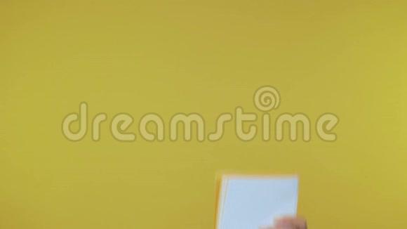 女性手在一个孤立的黄色背景上用钢笔在笔记本上做笔记4K视频的预览图