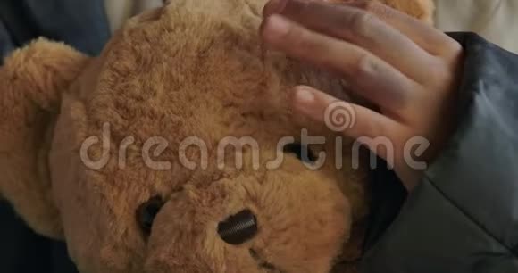 极端的特写肮脏无家可归的女孩她的手拿着泰迪熊疲惫的难民抚摸她可爱的玩具视频的预览图