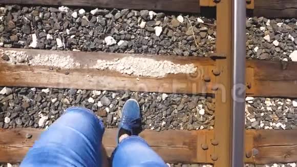 旅行者的腿在铁路上系着特写镜头游客踩着枕木乘客落后于火车视频的预览图