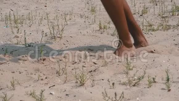 缺水的人在热天在热沙上散步男人的腿沙子上慢动作视频的预览图