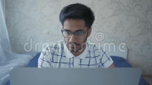 电脑上的印度学生打印文本从疲劳中取出眼镜和湿巾视频的预览图