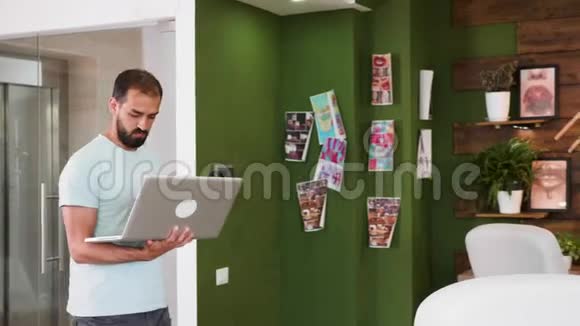 创意艺术总监拿着笔记本电脑走进办公室看着设计板视频的预览图