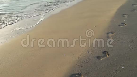 冲浪者在沙滩上挥动人类的脚印视频的预览图