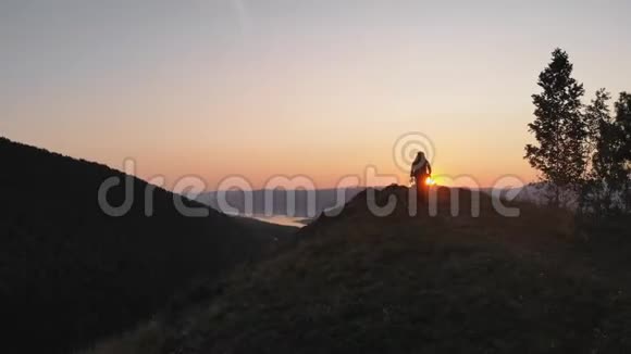 年轻的父亲和他的孩子站在山顶上欣赏山谷的美丽景色视频的预览图
