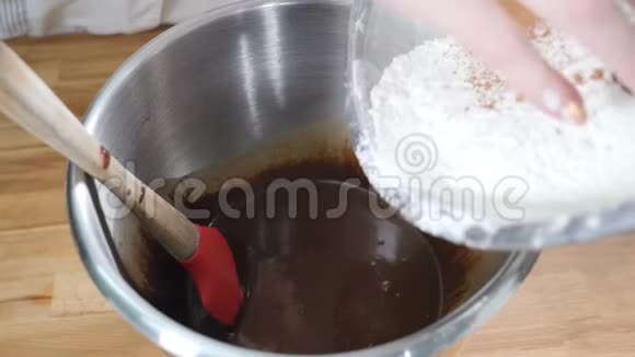 在面包店做巧克力蛋糕慢慢地把面粉倒入融化的巧克力中做糕点烹饪餐厅视频的预览图