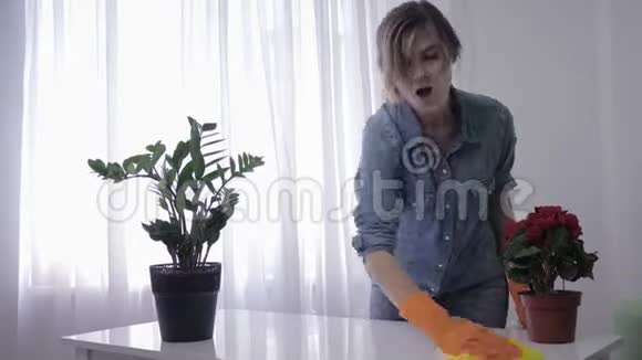 家庭过敏年轻女子在手套擦拭桌子打喷嚏因为刺激洗涤剂视频的预览图