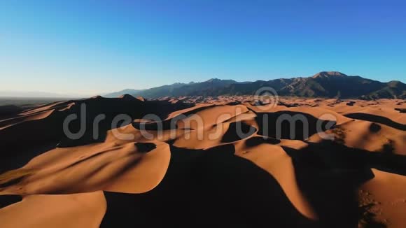 科罗拉多大沙丘国家公园地平线上有山的波浪状黄色沙丘全景视频的预览图