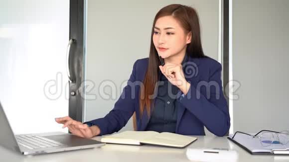 4k视频集中年轻美丽的亚洲年轻女性在办公室工作时坐在办公桌前使用笔记本电脑视频的预览图