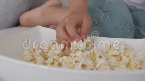 用爆米花做的特写菜妇女和儿童轮流碗里的谷物视频的预览图
