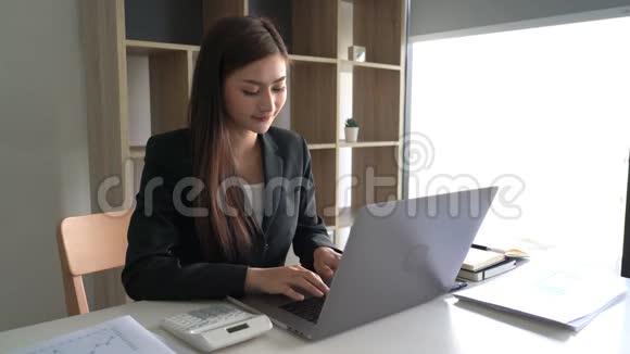 自信美丽的亚洲商界女性在笔记本电脑和工作站文件上从事新创业项目的4k视频视频的预览图