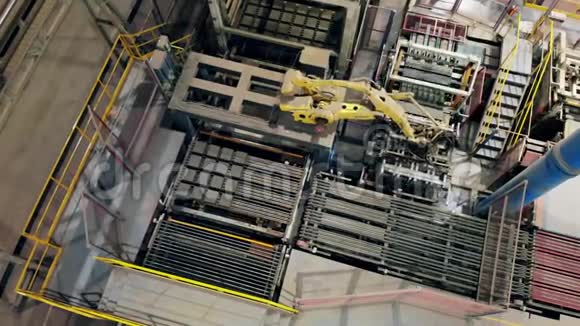 在阿莫登工厂地板上一个机器人手臂移动批次砖的顶部视图视频的预览图