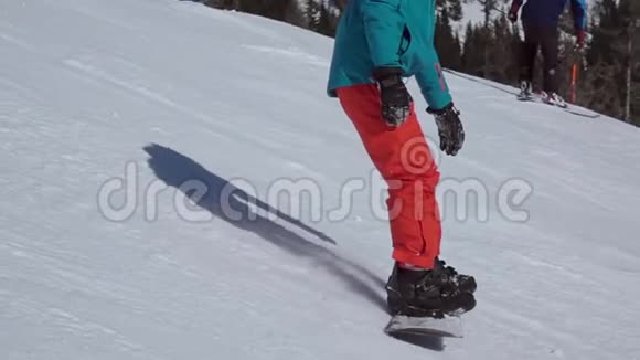 滑雪坡上穿红蓝西装的滑雪板慢动作视频的预览图