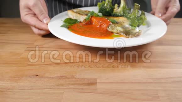 米其林星级餐厅美食概念男厨师拿着盘子和鱼盘配上绿色西兰花厨师服务视频的预览图