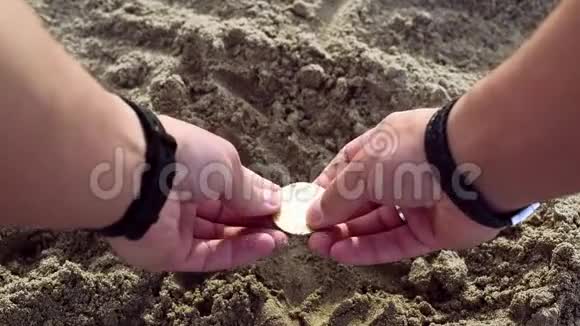 男性手在沙子里挖找到比特币视频的预览图