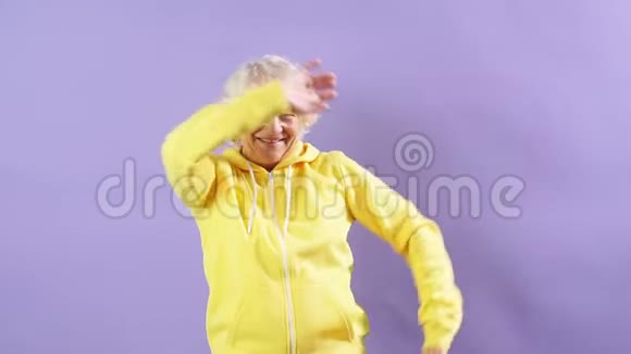 时髦的奶奶穿着黄色运动衫走向音乐跳舞聚会风格视频的预览图
