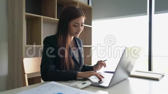 4k视频自信美丽的亚洲商界女性在笔记本电脑和工作站文件上与新创业项目合作视频的预览图