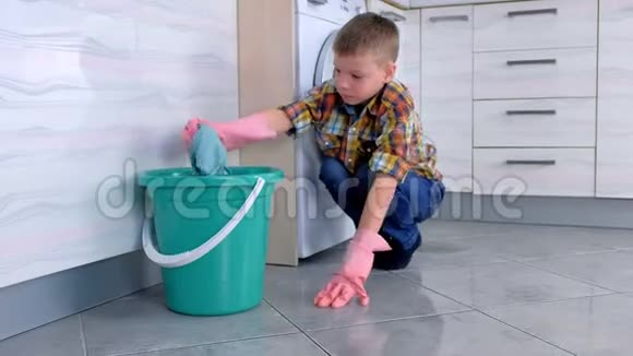 穿着橡胶手套的疲惫男孩不想在厨房里洗地板儿童的家庭责任视频的预览图