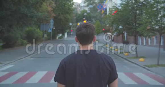 成年白种人运动男性慢跑者在城市户外沿街行走的特写照片视频的预览图