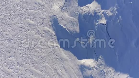 顶部俯瞰冰川覆盖雪裂缝和裂缝冬季户外爱好者4k架无人驾驶飞机视频的预览图