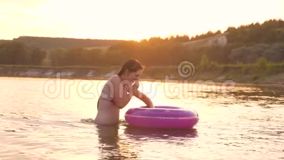 穿着泳衣的美丽而快乐的女孩潜入水中的充气圈笑了起来暑假视频的预览图