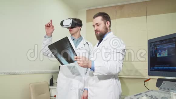 医生使用3dvr眼镜而他的同事检查了一个病人的x光视频的预览图