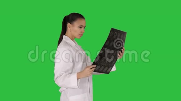 知识女性保健人员带白色实验衣看x射线摄影图像ct扫描绿色核磁共振成像视频的预览图