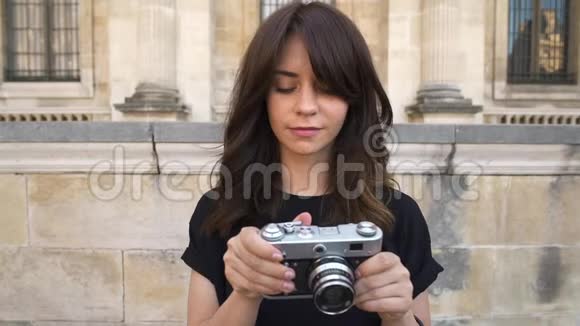 年轻女子在欧洲老城区背景下拍摄一部电影摄影机视频的预览图