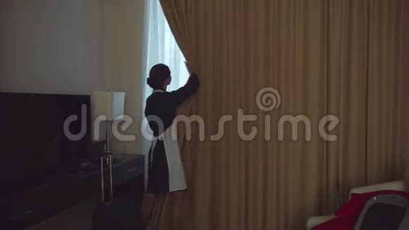 旅馆房间的窗户上的窗帘是由Housemaid打开的视频的预览图