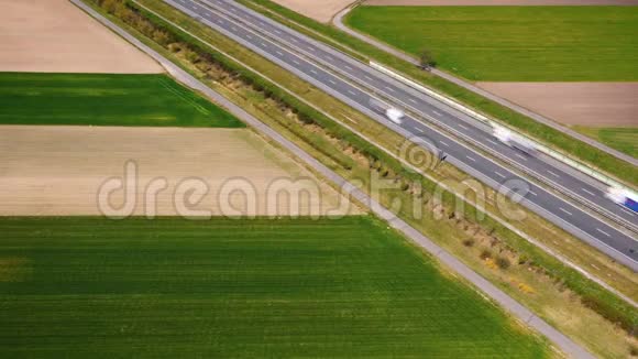 绿色田野间高速公路上的空中交通视野时间推移视频的预览图