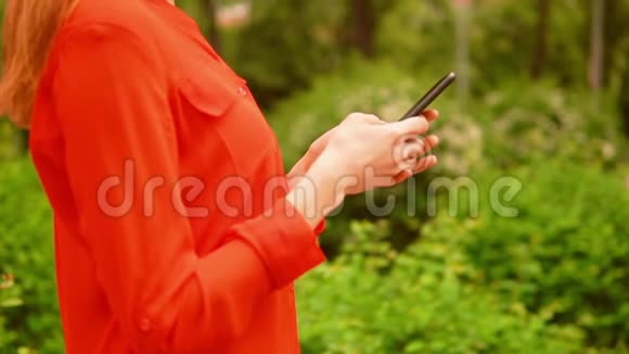 B卷侧视姜女走在街上拿着智能手机视频的预览图