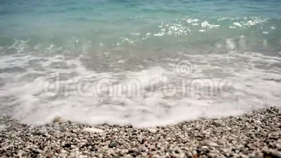 从沙滩上看女孩的脚被轻的海浪冲刷视频的预览图