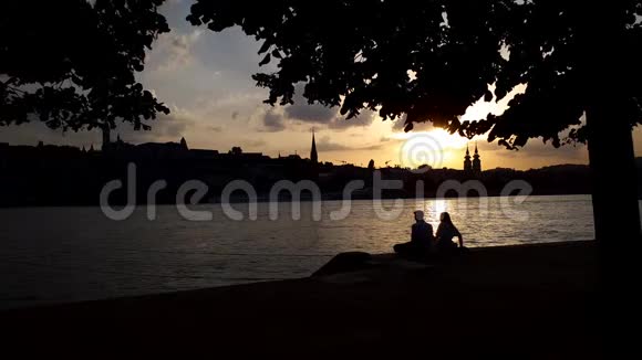 日落时分在码头上约会的年轻浪漫情侣剪影视频的预览图