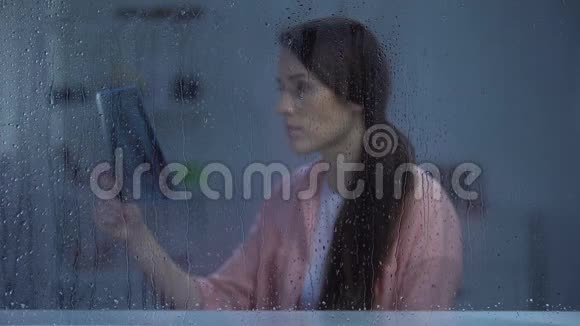 沮丧的女人在雨天看肺x光不治之症癌症视频的预览图