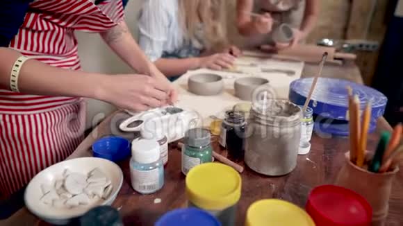 妇女团体在制陶车间工作制作陶杯和油漆视频的预览图