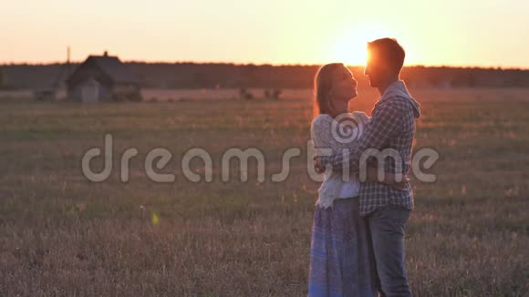 日落时和男人拥抱在一起的女孩视频的预览图