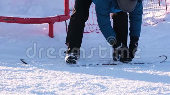 在冬天滑雪者穿上或移除滑雪板说是下坡视频的预览图