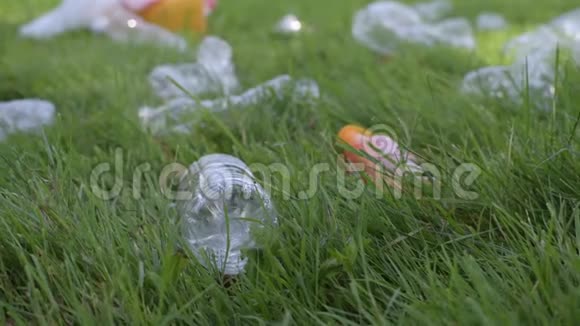 志愿者正在公共公园清理垃圾女人从草地上拿起塑料瓶环境污染视频的预览图