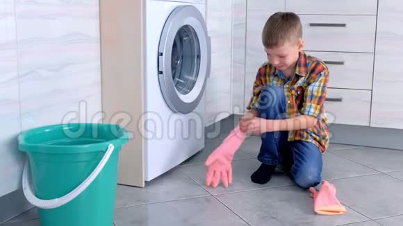 男孩戴上橡胶手套清洁厨房地板儿童的家庭责任视频的预览图