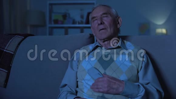 老人拿着遥控器睡在电视机前晚上在家视频的预览图