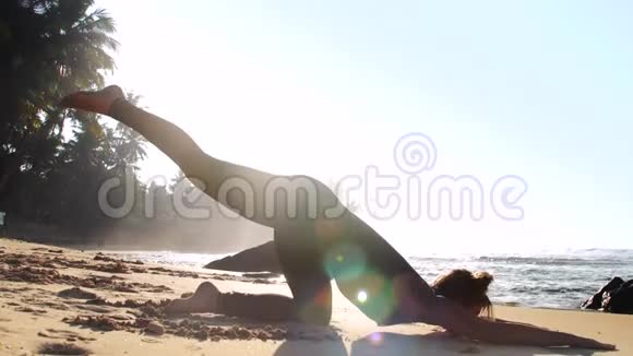 夏日阳光照耀下沙滩上的运动女孩剪影平衡视频的预览图